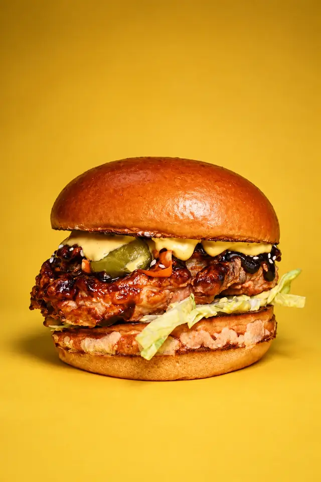Бургер на месеца BBQ Fried Chicken: пържено пиле с барбекю глазура, краставички, сусам и айсберг в питка бриош