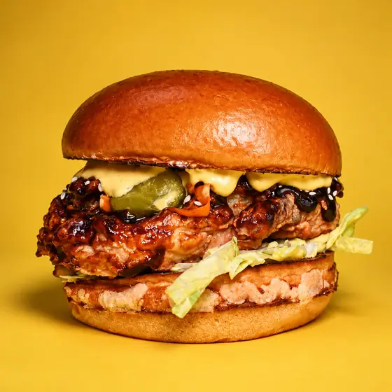 Бургер на месеца BBQ Fried Chicken: пържено пиле с барбекю глазура, краставички, сусам и айсберг в питка бриош